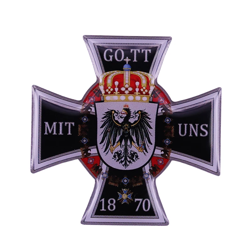 Železný krížový kolík je zdobený pruským orlom, kráľovou korunou a mottom: Gott MIT UNS (Boh je s nami).